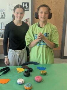Two Unified Art students posing with their yarn creations