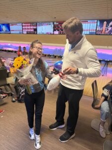 LSB Unified Bowling Senior Night: A student standing in a bowling alley with teacher